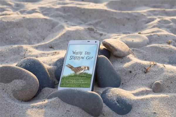 Where Did Sparrow Go book on smartphone lying on beach rocks